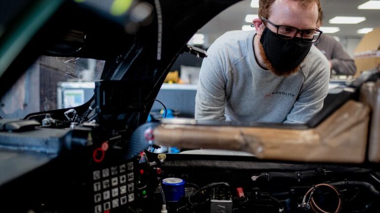 Jota partners with Monolith AI to enhance design and engineering with AI-driven data insights An automotive engineer wearing a face mask looks through the open window of a vehicle. The dash contains various testing equipment.