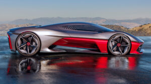 A sideview of the latest Corvette concept ca, inspired by Southern California. The car is sleek, grey and red, and is on an empty road in a rural location, with California hills in the background