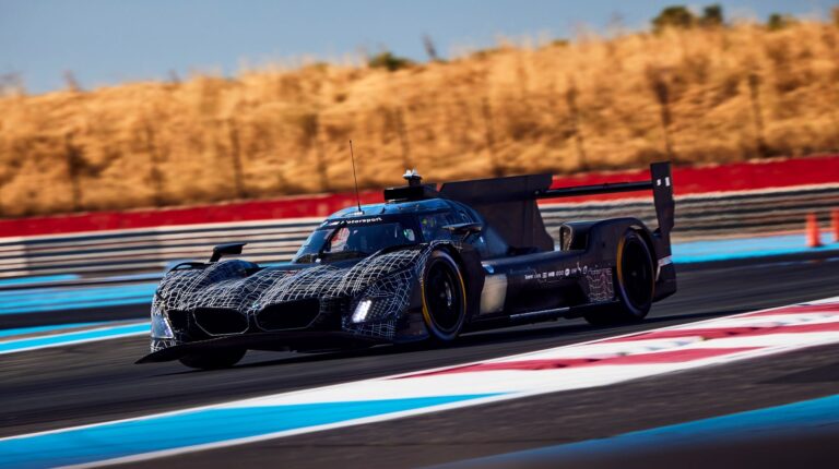 BMW M Hybrid V8 receives aerodynamic updates for 2026 season The BMW M Hybrid V8 takes a turn at high speed on a racetrack with hay bales in the background