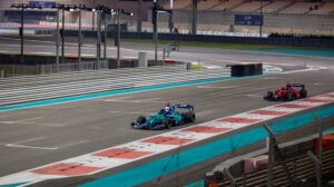 A Human vs AI demo at Yas Marina Circuit in Abu Dhabi, with two race cars driving down a straight.