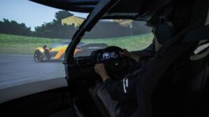 Inside of the Dynisma DMG simulator, with a driving cockpit and a large projected screen