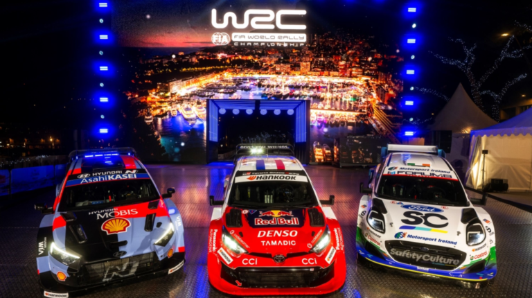 WRC 2026 gets underway in Monto Carlo with Hankook Ventus Z215 and Winter i*cept SR20 tires Three rally cars sit on a promotional stage in front of WRC logo and branding at the season opener in Monte Carlo. The cars are red, black and white.