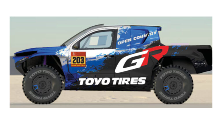 Toyota Gazoo Racing and Toyo Tire continue partnership for W2RC 2026 The DKR GR Hilux with a predominantly black and blue livery, has red and white writing down the side that says 'Toyo Tire'