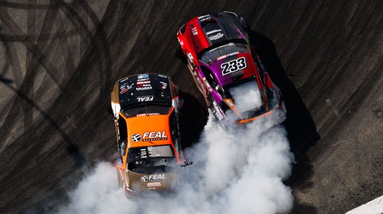 Formula Drift announces race format changes following partnership with Race Data Labs Two Formula Drift cars - one red, one orange and black - in competition, with white smoke coming out the back of the vehicles.