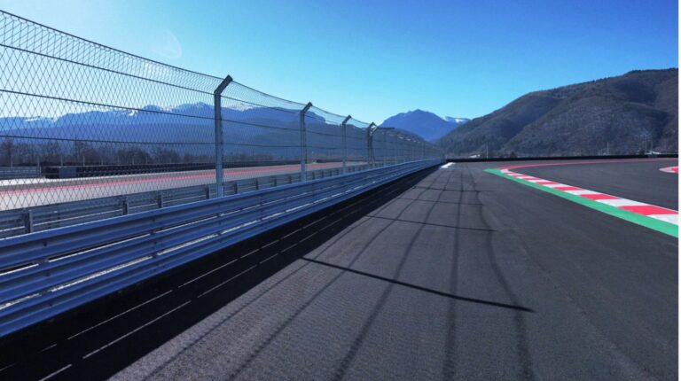 Geobrugg recognized with top FIA environmental accreditation Geobrugg fence circuit safety solution at a racetrack with mountains visible in the distance