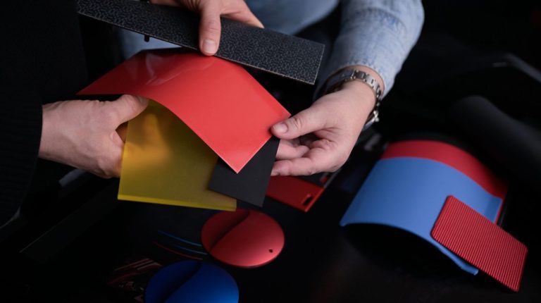 Bcomp supplies biocomposites for BMW M Concept Neue Klasse A person looks through a range of Bcomp and BMW M biocomposite material samples in a range of colors